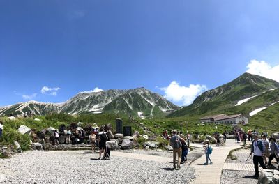 People on mountains against sky