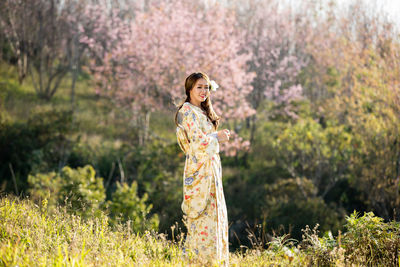 Woman standing by flowers