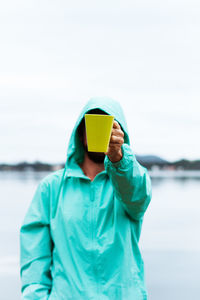 Rear view of person using a mug coffee in front of the face