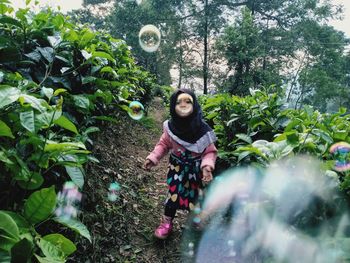 Portrait of woman standing against plants