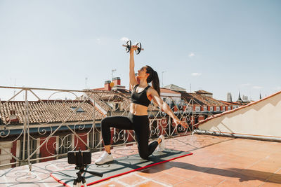 Low angle view of woman walking on steps against clear sky