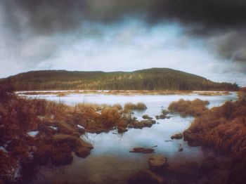 Scenic view of lake against cloudy sky