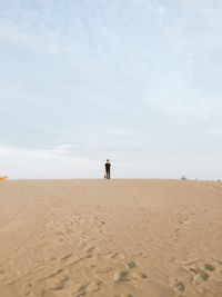 Man standing on beach against sky