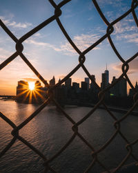 Close-up of cityscape seen through chainlink fence