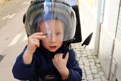 Portrait of a little boy in a motorcycle helmet. child in motorcycle helmet with closed visor. 