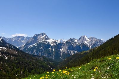 Scenic view of snowcapped mountains against clear blue sky