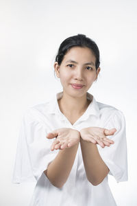 Portrait of smiling young woman against white background