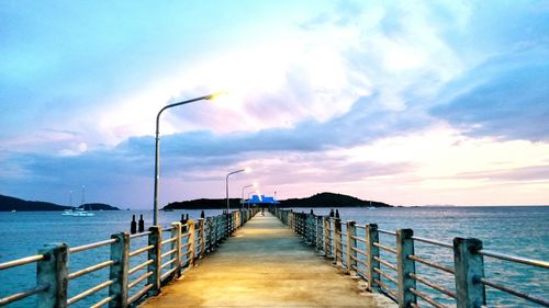 Pier on sea against sky during sunset