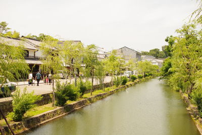 River amidst trees and buildings against sky