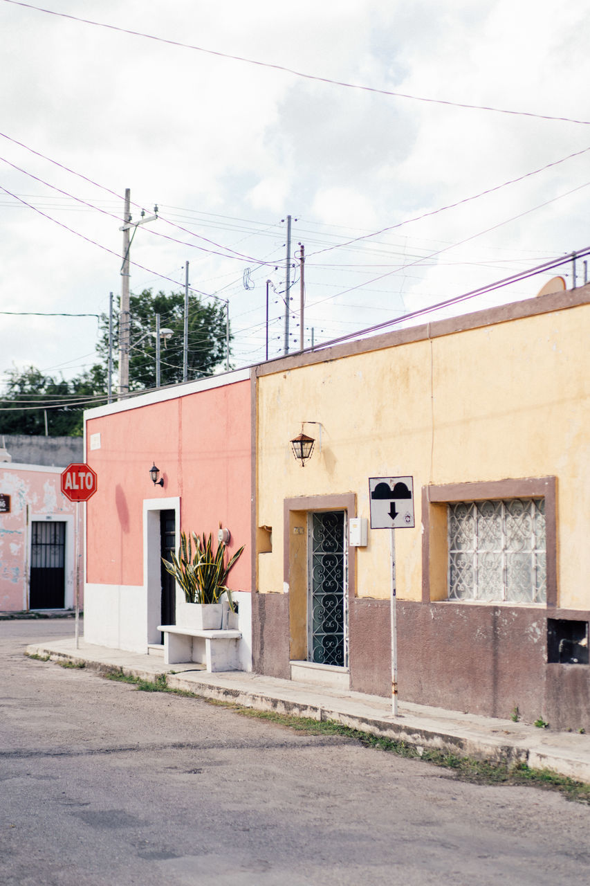 architecture, built structure, building exterior, electricity, city, cable, street, sky, neighbourhood, no people, cloud, building, day, nature, road, power line, residential area, entrance, transportation, outdoors, house, town, technology, store, facade