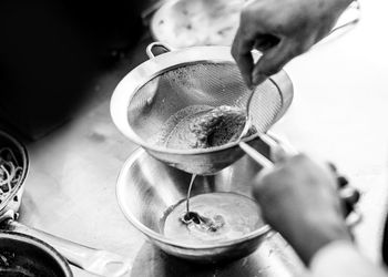 Close-up of hand pouring tea cup