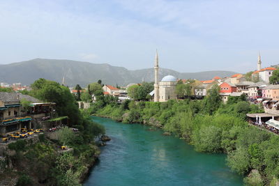 River amidst buildings in town against sky
