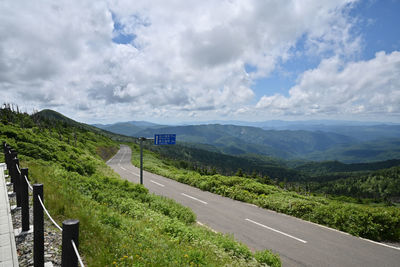 Road leading towards mountains against sky