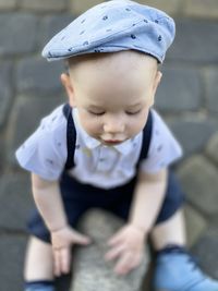Portrait of a boy one year old wearing a retro country style helmet beret , excitement and dynamism 