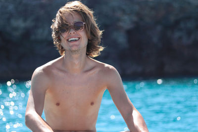 Laughing boy enjoying freedom on luxury yacht deck relaxing on boat summer vacation trip.