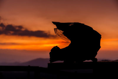 Silhouette full face motorcycle helmet at sunset