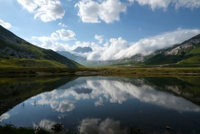 Scenic view of lake and mountains against sky