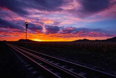 Railroad tracks against sky during sunset