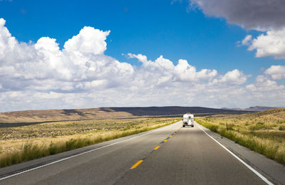 Road amidst green landscape against sky