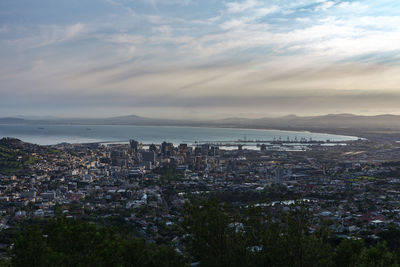 High angle view of city by sea against sky