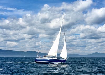 Sailboat in sea against blue sky