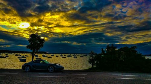 Car on road against sky during sunset