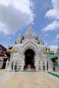 Facade of temple building against cloudy sky