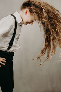 Close-up of girl with long hair against wall