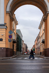 Man walking on street amidst buildings in city