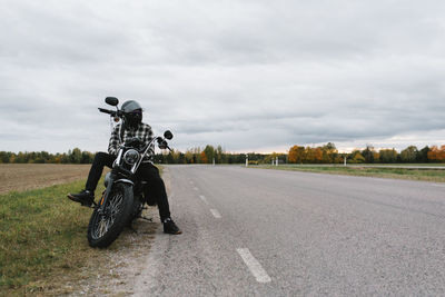 Horse riding motorcycle on road against sky in city