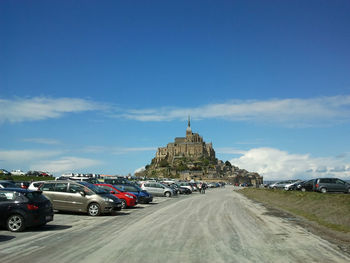 Cars on road against blue sky