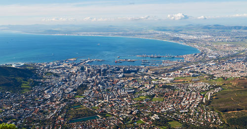 High angle view of townscape by sea against sky