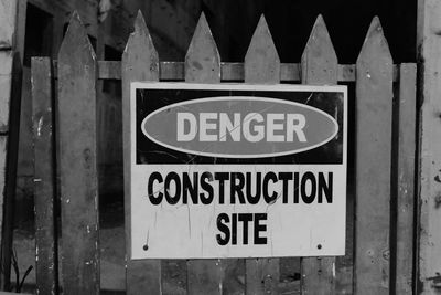 Close-up of warning sign on metal fence