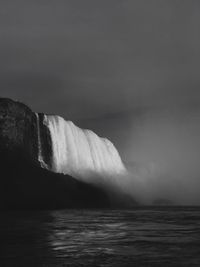 Scenic view of waterfall against sky