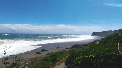 Scenic view of beach against blue sky