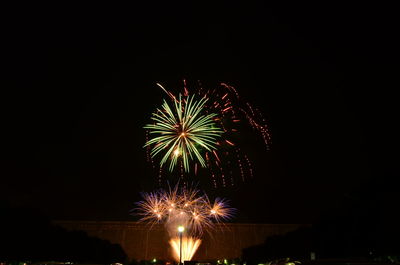 Low angle view of firework display against sky at night