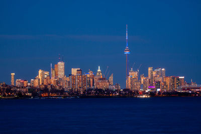 Illuminated buildings in city against sky at night