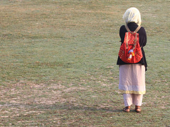 Rear view of woman standing on field