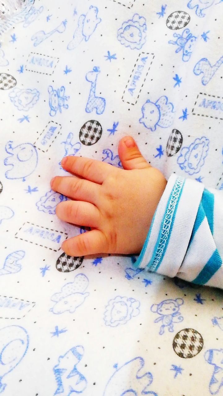 child, real people, childhood, one person, human body part, bed, indoors, baby, body part, human hand, hand, young, pattern, babyhood, relaxation, book, floral pattern, low section, innocence, human foot, finger