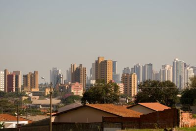 Buildings in city against clear sky