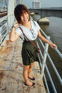 Portrait of smiling young woman standing in water