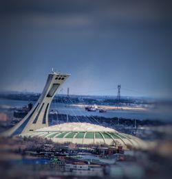 Airplane on airport runway against sky in city