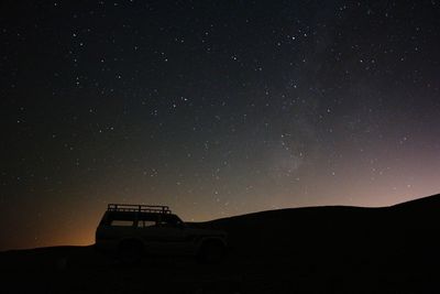 Silhouette landscape against sky at night