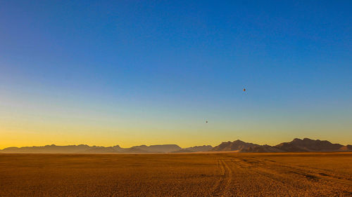 Scenic view of field against clear blue sky