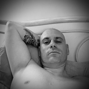 Portrait of shirtless man lying down at home