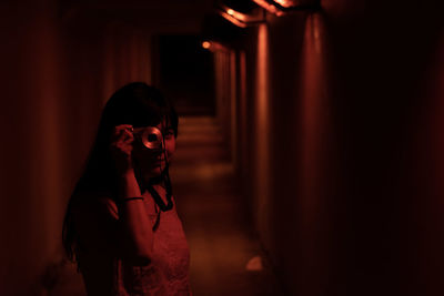 Full length of woman standing in illuminated mirror