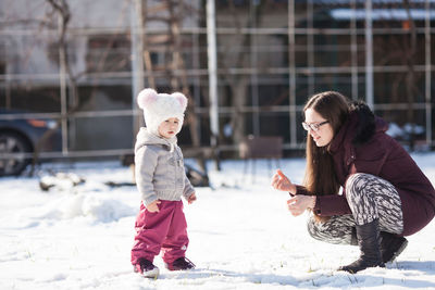 Full length of girl standing in snow