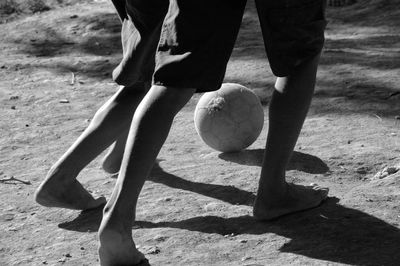 Low section of boys playing soccer on field