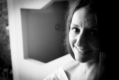 Close-up portrait of smiling woman at home