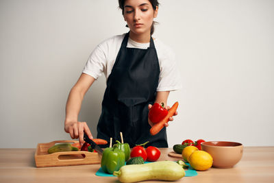 Young man with vegetables on cutting board